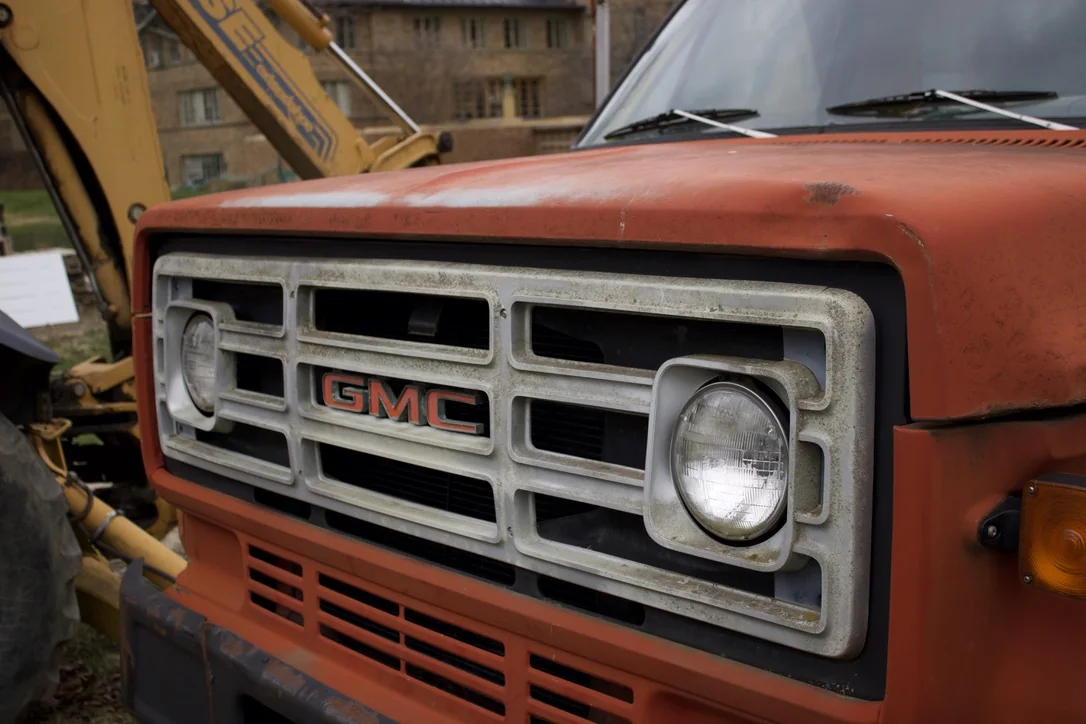 The grille of an old orange GMC truck